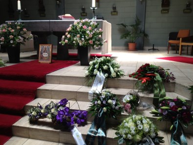 Bloemen bij de uitvaart van pastoor Woolderink op de trappen van het altaar