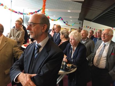 Pater Tom Buitendijk (links) luistert naar goede woorden tijdens de receptie